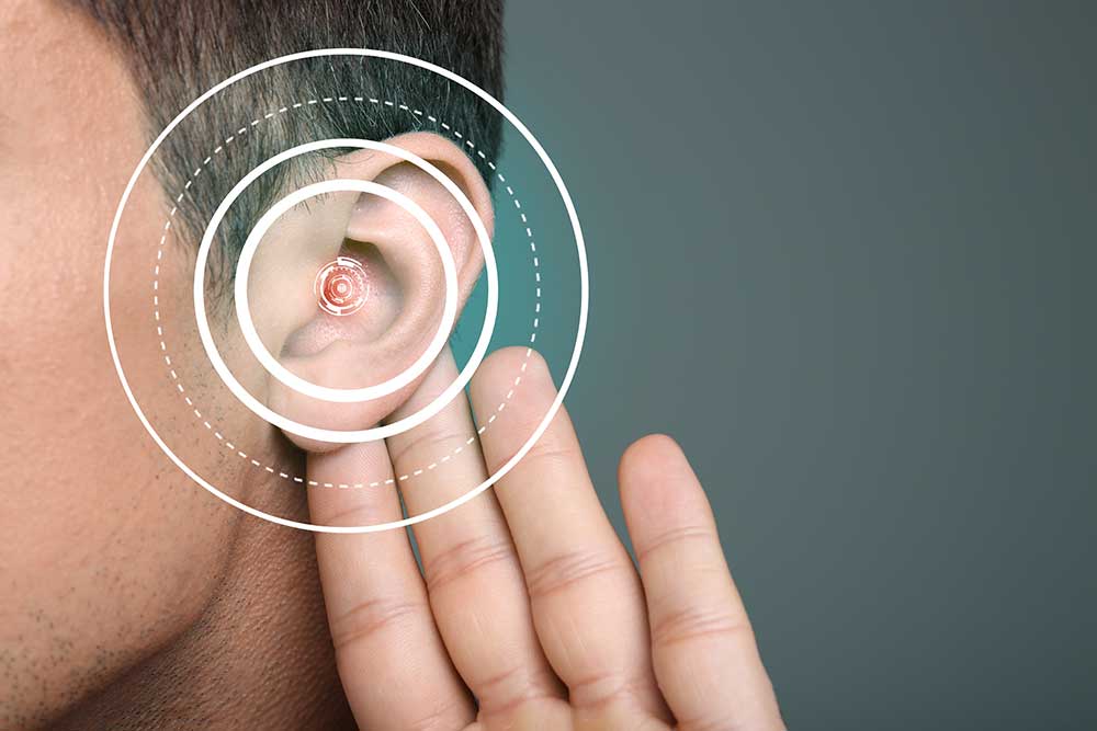 A close-up of a person’s ear with concentric digital circles over it, suggesting hearing or sound waves, while a hand is cupped behind the ear as if trying to listen more closely.